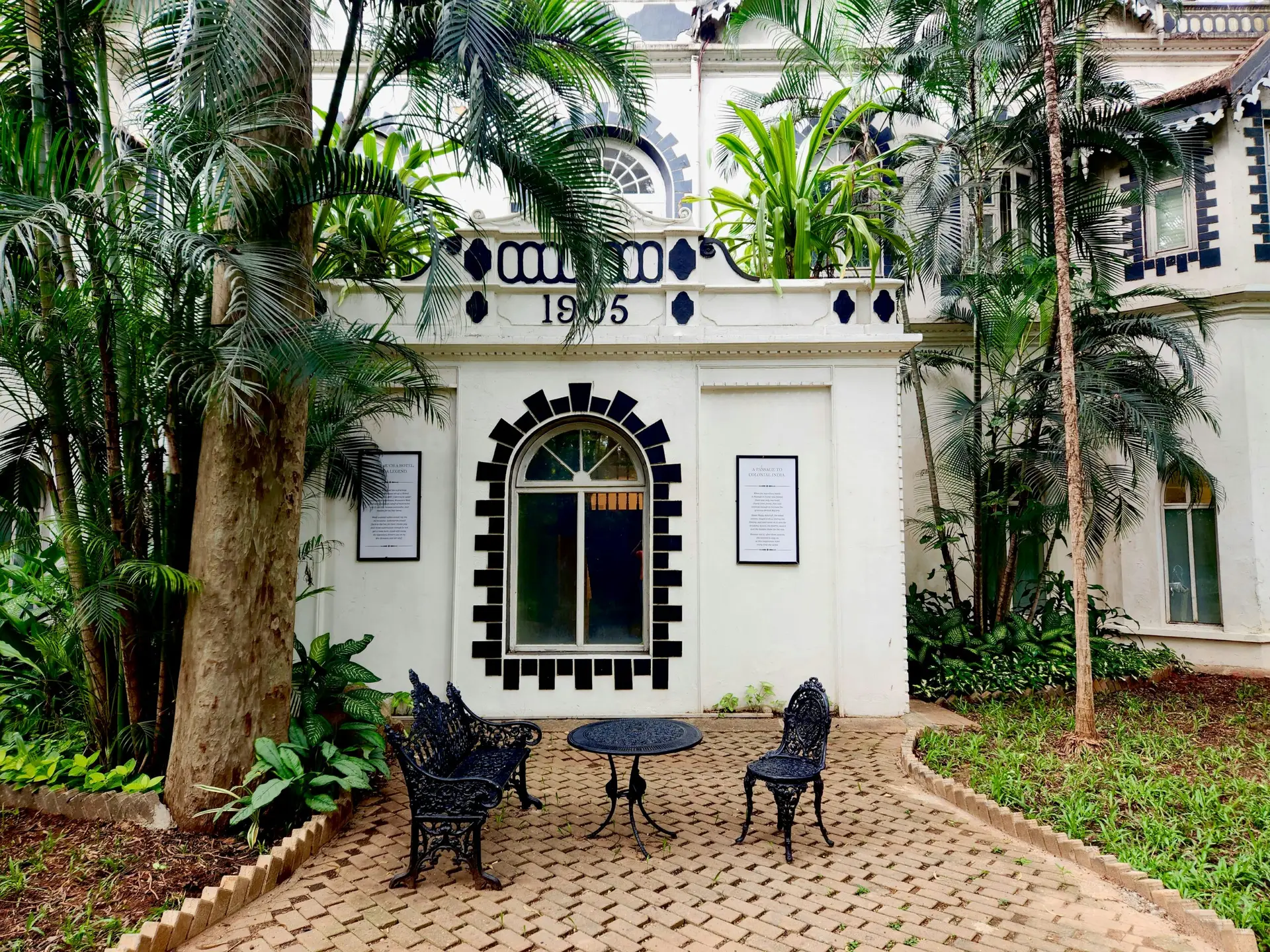 a patio with a table and chairs in front of a building